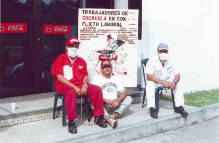 ArbeiterInnen von Coca Cola - Kolumbien ketten sich aus Protest gegen die
gewerkschaftsfeindliche Politik des Unternehmens vor dem Betrieb an

